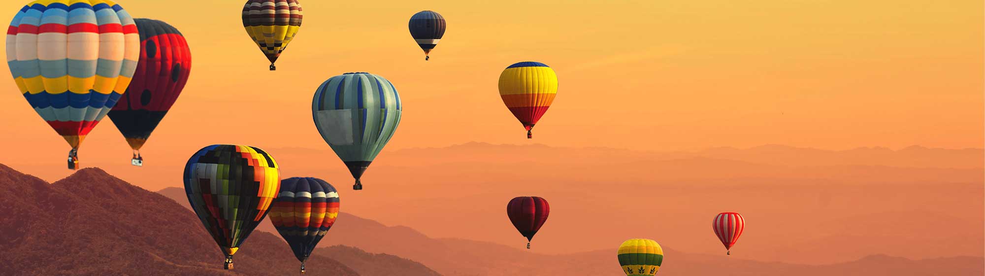 Montgolfières colorées traversent une chaîne de montagnes