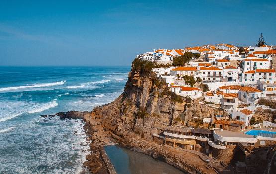 Vue aérienne de bâtiments blancs aux toits rouges sur une falaise au bord de la mer 