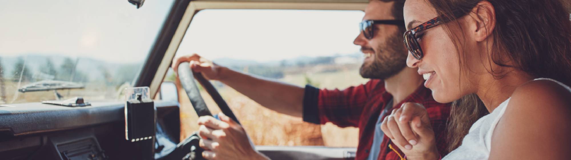 Deux personnes dans un van : l'une est en train de conduire tandis que la deuxième cherche le chemin. 