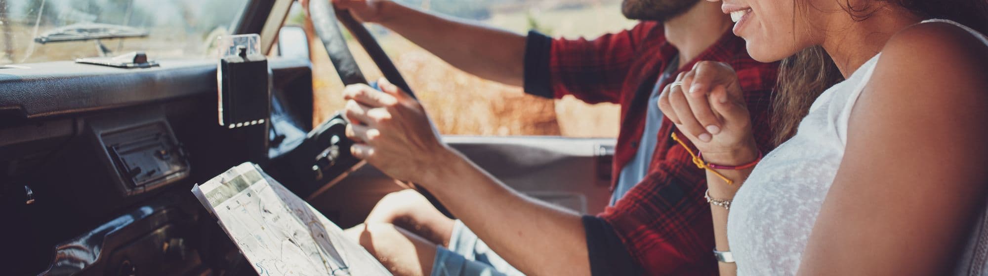 Deux personnes dans un van : l'une est en train de conduire tandis que la deuxième cherche le chemin. 