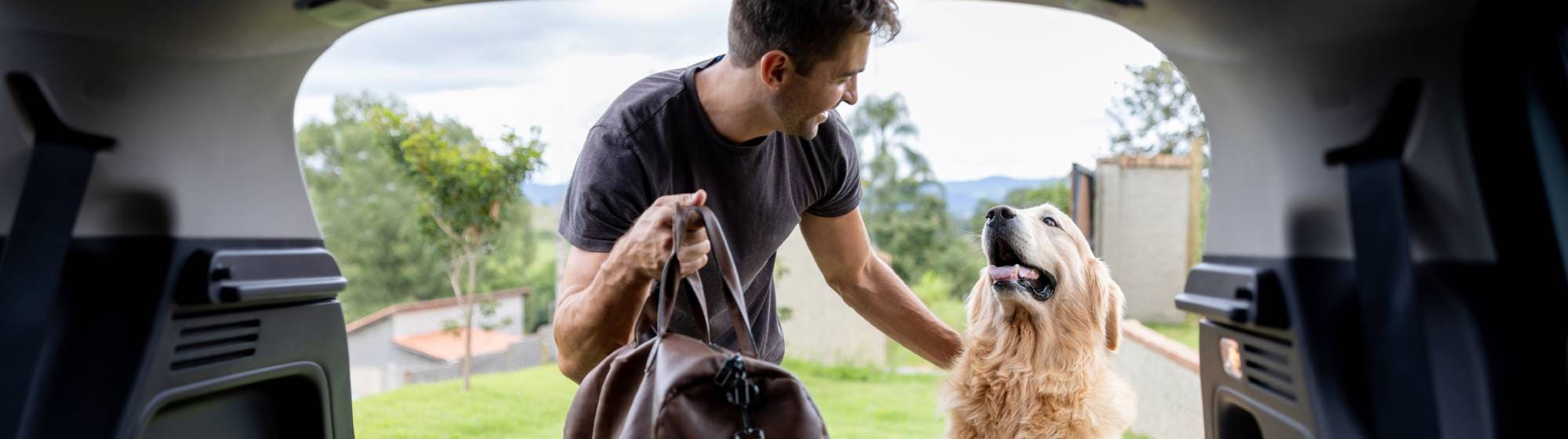 Un chien et son maître au coffre d'une voiture