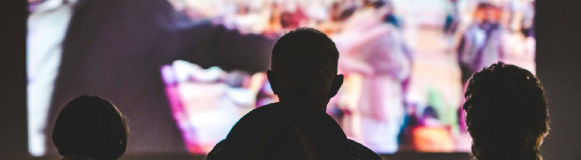 Des personnes regardant l'écran du festival. 