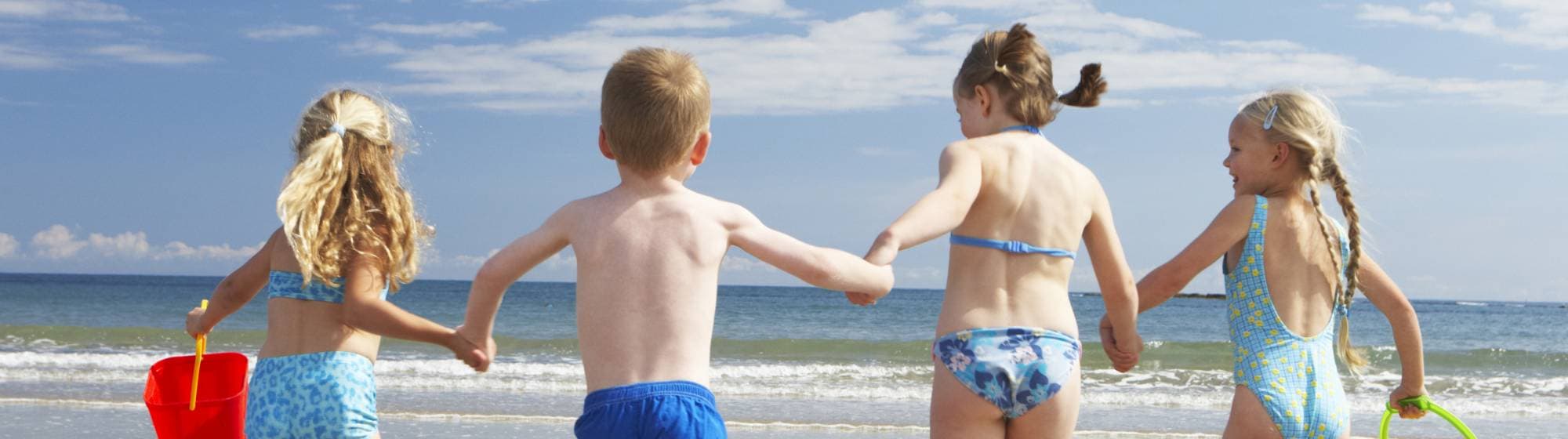 4 enfants à la plage en maillot de bain