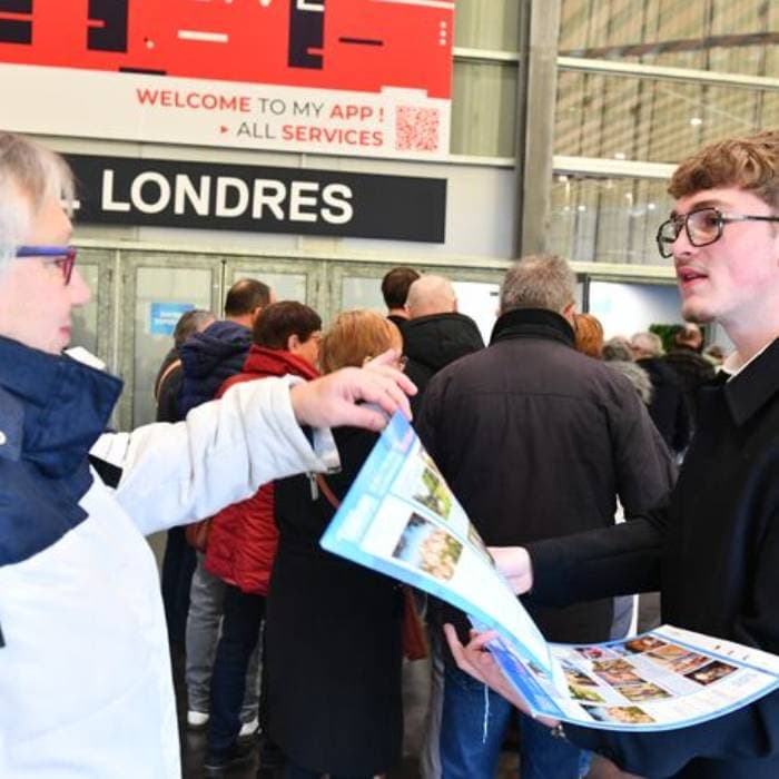 un garçon qui distribue le guide de visite