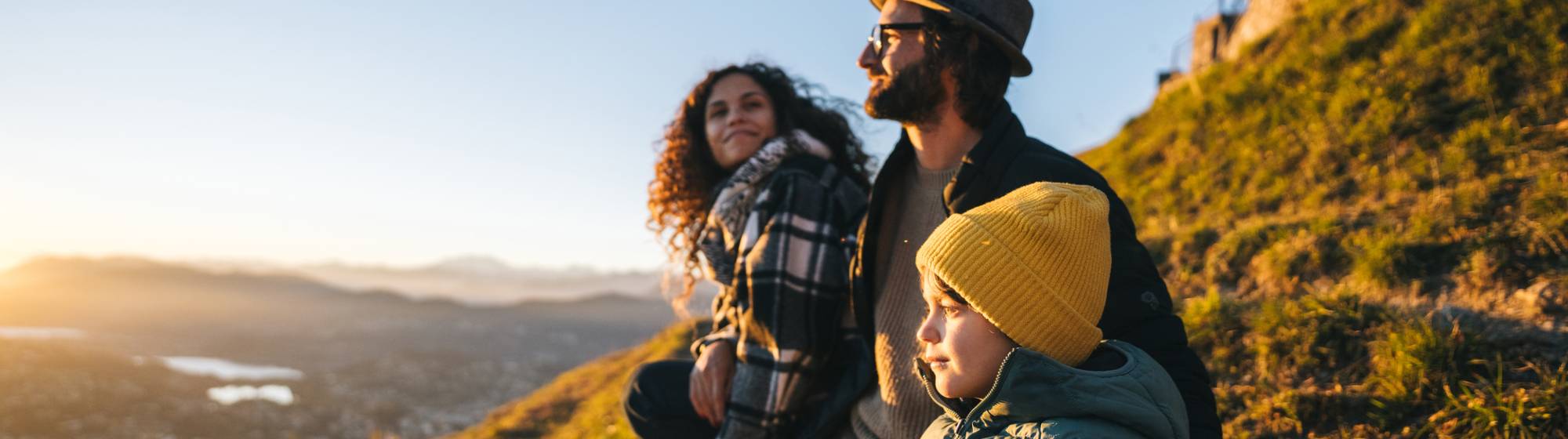 des parents avec un enfant assis sur l'herbe