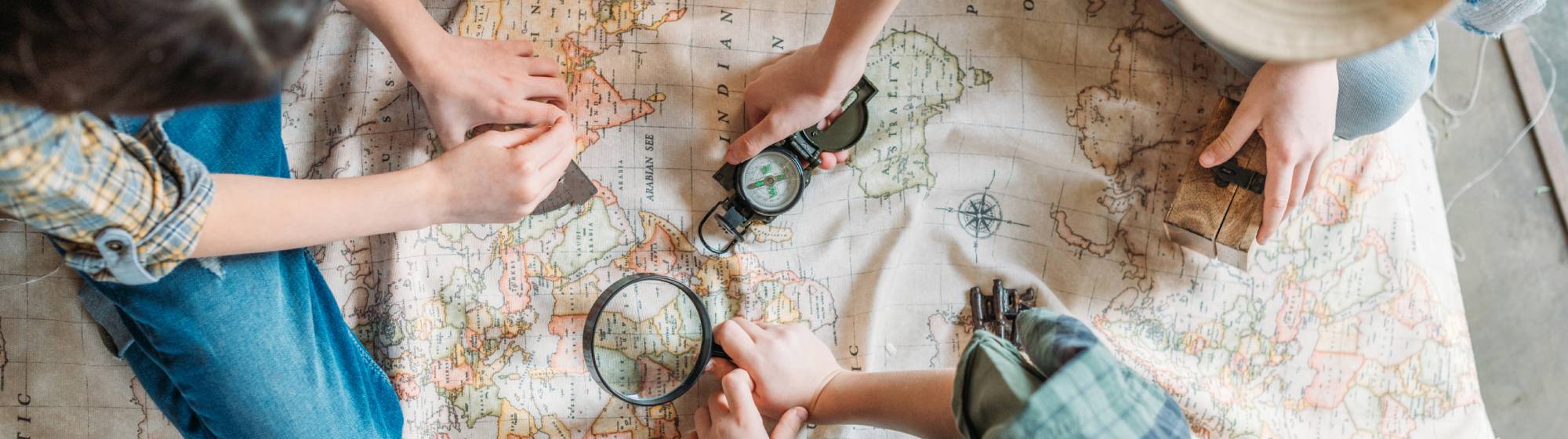 des enfants qui jouent sur une carte avec une loupe