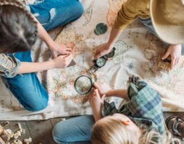 des enfants qui jouent sur une carte avec une loupe