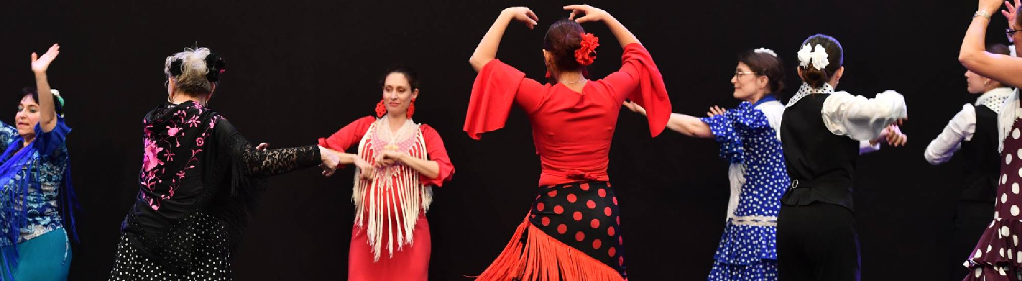 Des femmes habillées en costume d'époque qui dansent. 