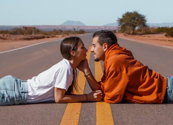 un couple qui s'embrasse allongé sur la route