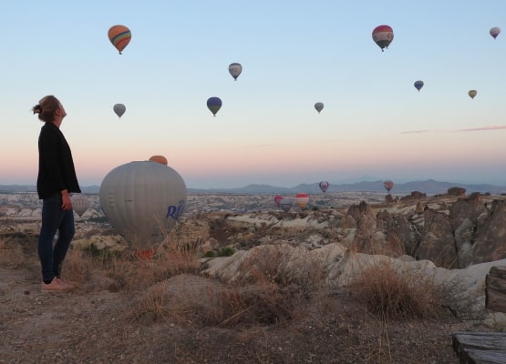 Femme qui regarde le ciel de montgolfiere en Turquie