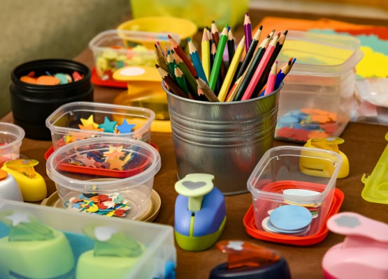 Des crayons de couleurs et de la peinture sur une table