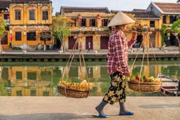 une femme asiatique portant deux paniers