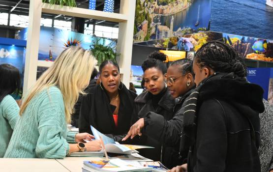 Un groupe de visiteurs discutant avec un exposant au Salon Mondial du Tourisme de Paris