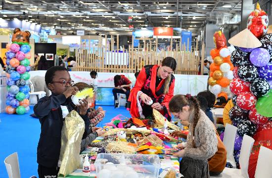 Une dame jouant avec les enfants sur l'espace des enfants sur le salon Mondial du Tourisme. 