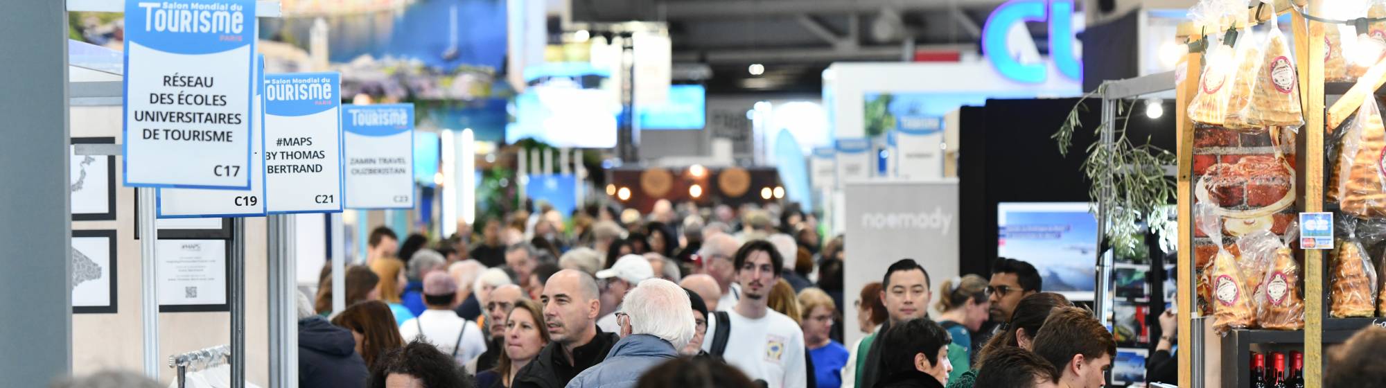 des visiteurs qui regardent des stands du salon