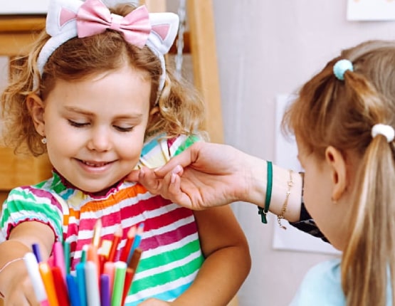 Une mère et ses 2 filles qui font un coloriage