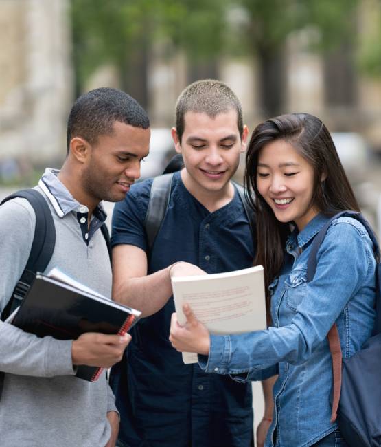 2 étudiants et 1 étudiante qui regardent un document