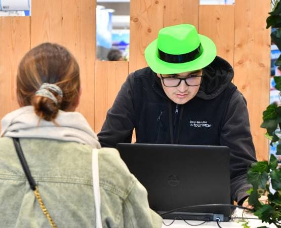 un hôte qui aide une personne à faire son badge