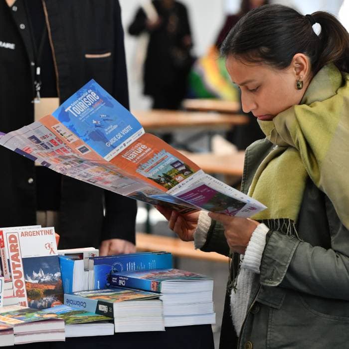 une personne qui regarde le guide de visite