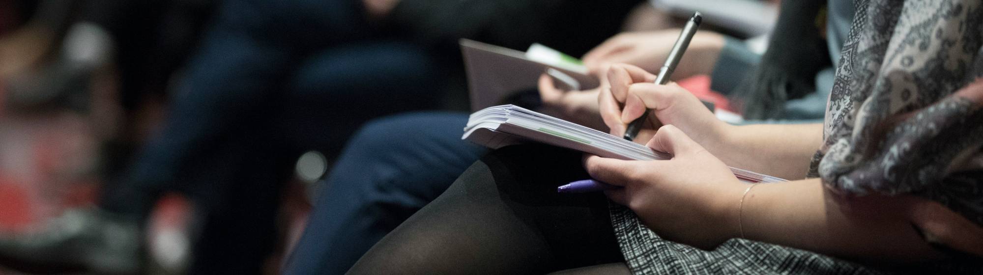 une femme qui prend des notes sur un carnet