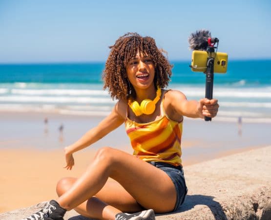 une femme sur la plage qui fait un vlog