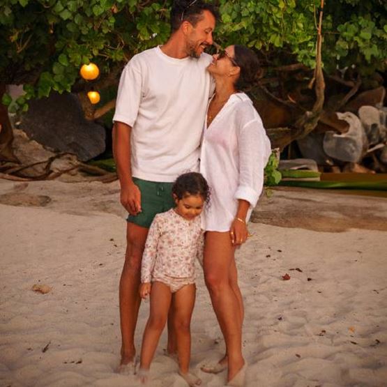 Un couple avec un enfant sur une plage.