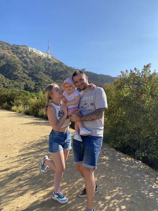 Un couple avec un enfant posant sur un sentier.