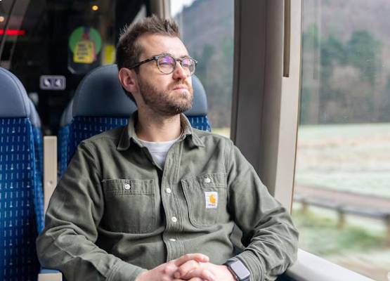un homme qui regarde à travers la vitre d'un train