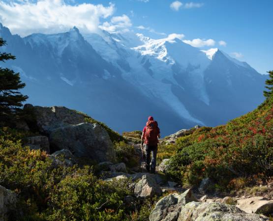 un homme en randonnée face à la montagne