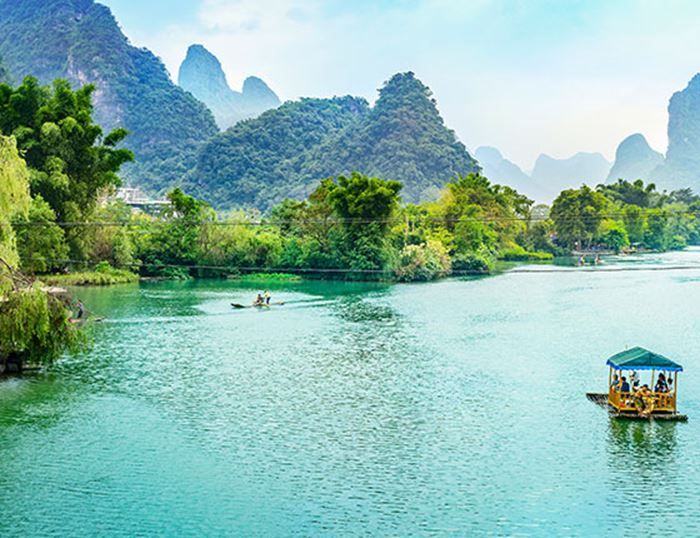 Un radeau navigue sur un fleuve au cœur de la forêt tropicale