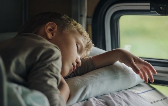 Un jeune enfant dormant dans un train. 