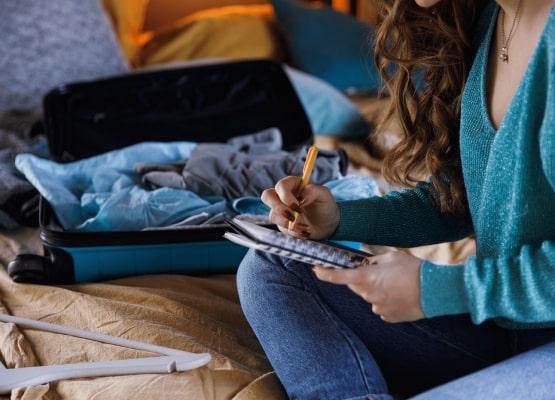 Une fille qui fait une liste pour sa valise