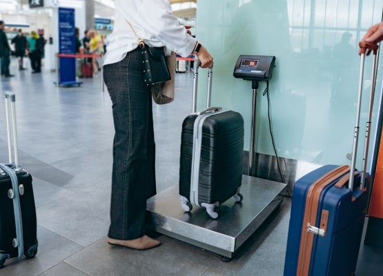 Un homme qui pèse sa valise à l'aéroport