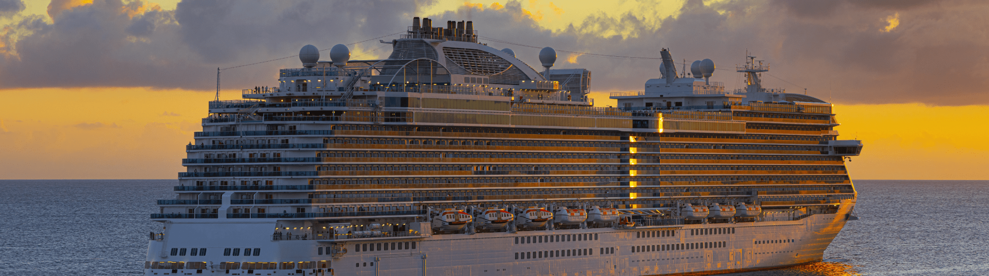 Un bateau de croisisère devant un coucher de soleil