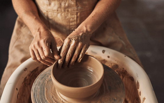 Ouvrier de poterie avec un pot en argile dans un atelier