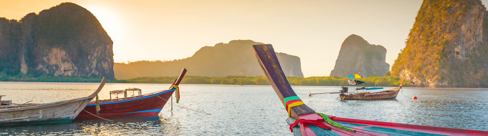 Des barques naviguant face au coucher de soleil