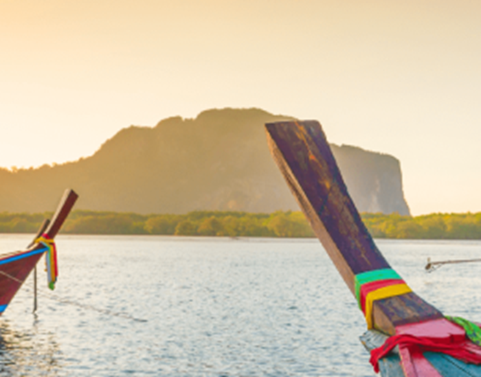 Des barques naviguant face au coucher de soleil