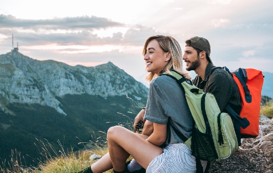 Un couple admirant la vue après une randonnée en montagne. 