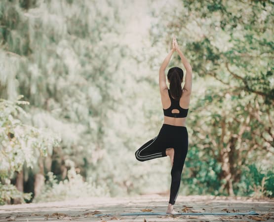 Une femme réalise une pause de yoga en pleine nature