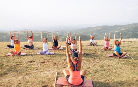 Des personnes assisent en train de faire du yoga.