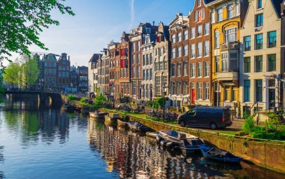 Canal bordé de maisons traditionnelles au centre d’Amsterdam