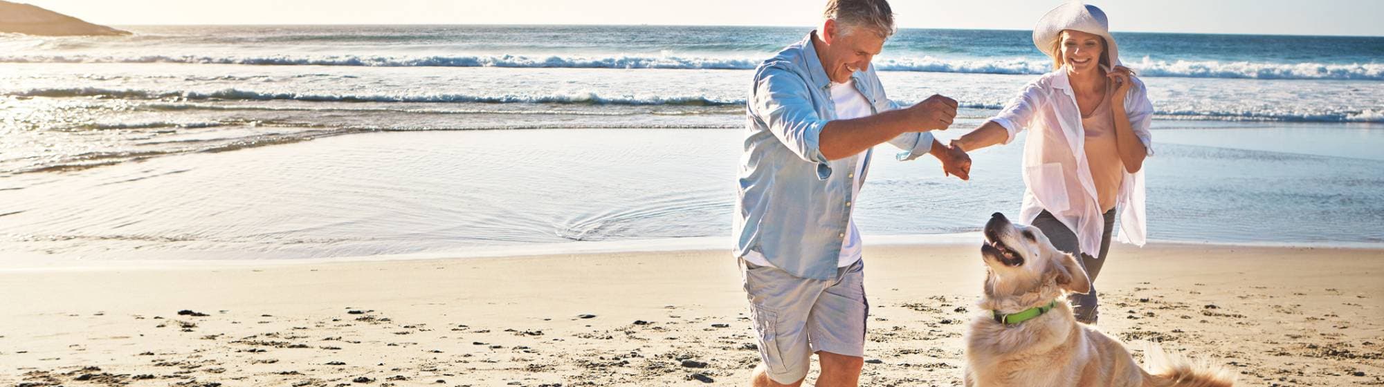 un couple à la plage avec leur chien qui s'amusent