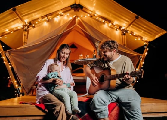 une famille dans une cabane joue de la guitare
